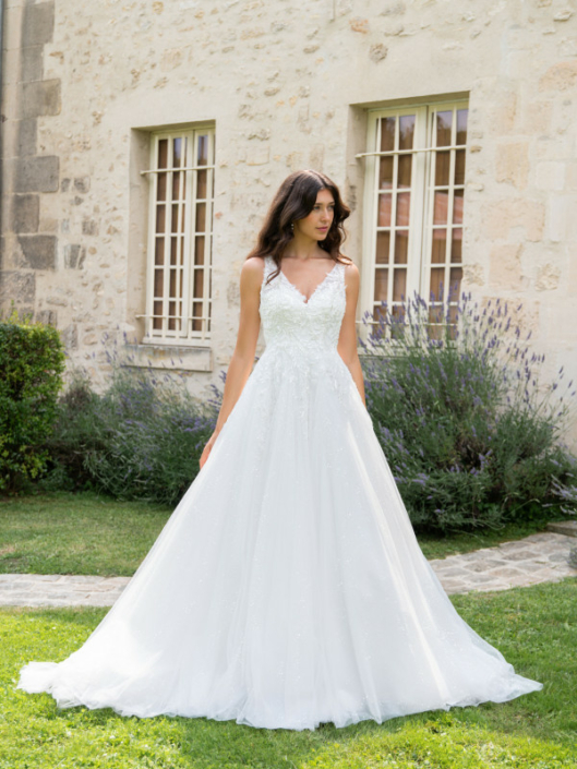 Robe de mariée «Félicia» de chez Framboise Paris. Cette robe de mariée est confectionnée en dentelle sur le buste et d’un tulle souple paillette sur la jupe avec une fermeture en lacet. Style trapèze ou princesse selon le cerceau. Cette robe de mariée est disponible dans votre boutique Rêve d'un Jour à Yvetot