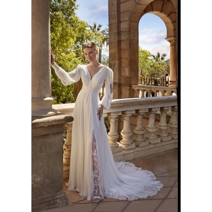 Robe de mariée «Hestia» de chez Ellebeline Paris. Cette robe de mariée avec des manches est toute en mousseline et drapée avec une transparence dentelle et sequins. Style déesse grecque. Cette robe de mariée est disponible dans votre boutique Rêve d'un Jour à Yvetot