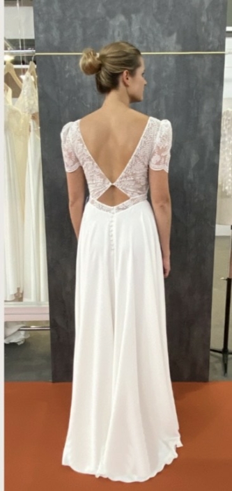 Robe de mariée «Rym» de chez Lambert Création. Cette robe de mariée en dentelle et crêpe et en création et fabrication 100% Français. Cette pépite est disponible dans votre boutique Rêve d'un Jour à Yvetot