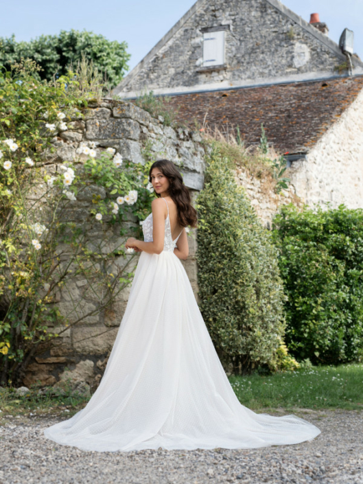 Robe de mariée «Leslie» de chez Framboise Paris. Cette robe de mariée est confectionnée en dentelle Plumetis sur le buste et d’un tulle souple en Plumetis sur la jupe avec une fermeture en V. Style trapèze ou princesse selon le cerceau. Cette robe de mariée est disponible dans votre boutique Rêve d'un Jour à Yvetot