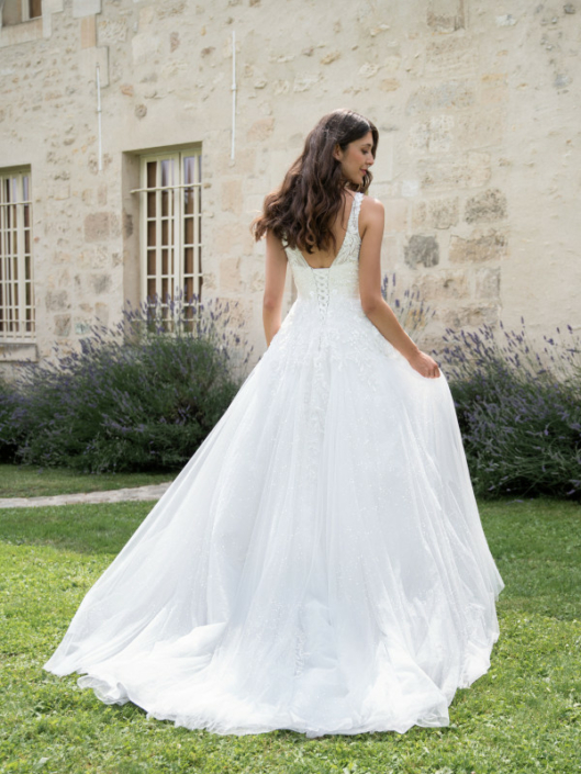 Robe de mariée «Félicia» de chez Framboise Paris. Cette robe de mariée est confectionnée en dentelle sur le buste et d’un tulle souple paillette sur la jupe avec une fermeture en lacet. Style trapèze ou princesse selon le cerceau. Cette robe de mariée est disponible dans votre boutique Rêve d'un Jour à Yvetot