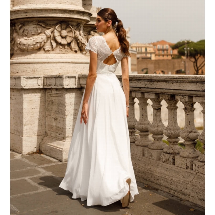 Robe de mariée «Olympia» de chez Ellebeline Paris. Cette robe de mariée se compose d’un buste en dentelle avec un dos papillon et d’une jupe en mousseline. Style bohème chic. Cette robe de mariée est disponible dans votre boutique Rêve d'un Jour à Yvetot